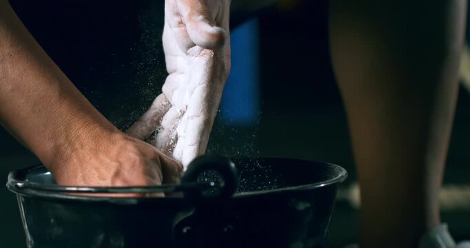 Slow Motion Macro Shot Of Chalk Covered Hands Dipping Into Gym Bowl And Creating White Dust Cloud Before Training Session At 1000 Fps.Concept Of Mental Preparation, Ritual, Strength, Athletic Crossfit