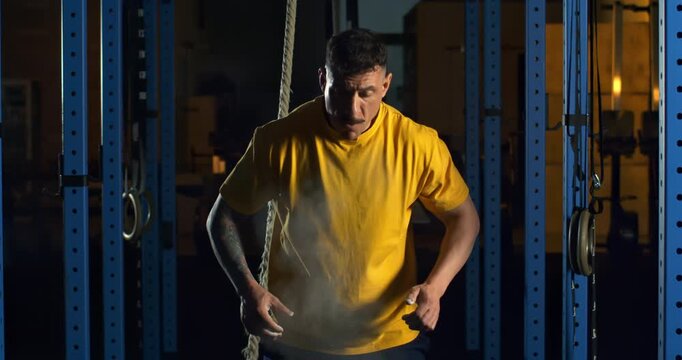 CrossFit Athlete Preparing Hands With Chalk Before Workout, Industrial Gym Atmosphere, Concept Of Ritual, Focus, Strength Building And Mental Preparation Before Challenge at 1000 fps