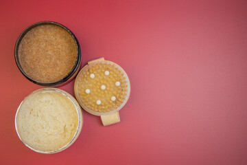Three jars of body scrubs with different textures and colors are displayed on a red background, highlighting skincare products and inviting beauty enthusiasts to explore