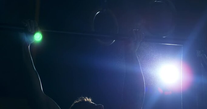 Slow Motion Close Up Shot Of Crossfit Athlete Performing Pull Ups Muscle Up Transition On Bar Under Industrial Light At 1000 Fps. Concept Of Strength, Progress, Mental Discipline In Training