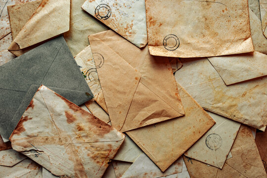 Collection of vintage envelopes in antique with weathered edges piled together