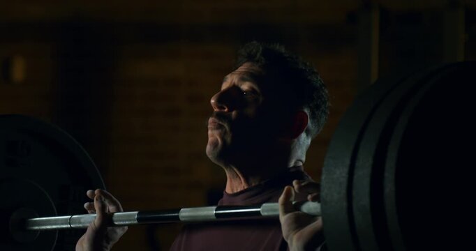 Slow Motion Close Up Of Crossfit Athlete Performing Pull Ups Muscle Up Transition On Bar Under Industrial Light At 1000 Fps. Concept Of Strength, Progress, Mental Discipline In Training