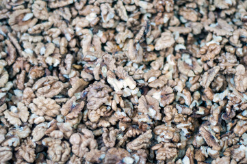 Shelled walnut pieces forming background, showcasing healthy snack