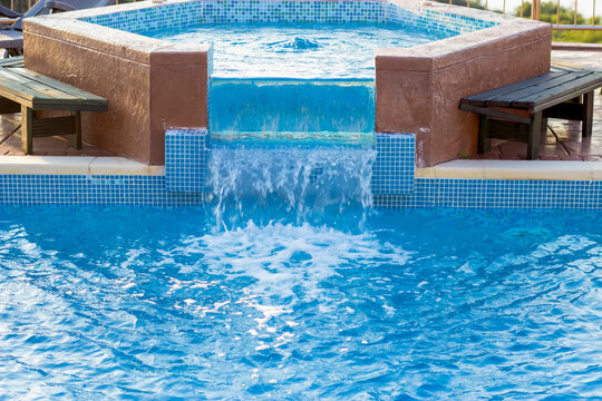 Swimming pool with jacuzzi overflow and clear blue water - Powered by Adobe
