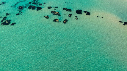 Aerial view of the surface of an exotic sea. The water is turquoise and azure. Ideal for textures, patterns, and backgrounds.