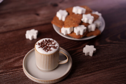 warm cappuccino with chocolate sprinkles and christmas star cookies on rustic wooden table setting with cozy atmosphere, afternoon, inviting, background, wood, texture, festive, holiday, homemade