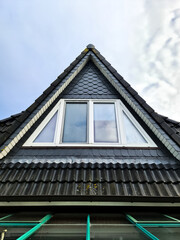 Gable roof with triangular window and slate tiles