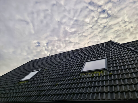 Roof skylights on house against cloudy sky