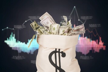 Money bag with dollars bills on a desk