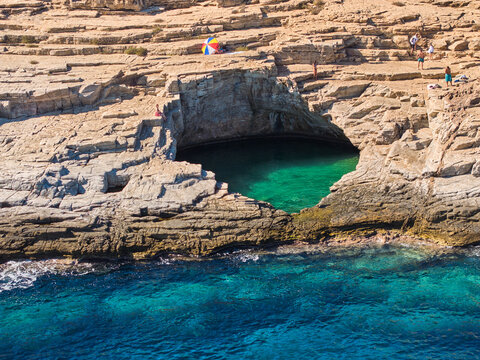 Giola rock pool on Thassos with swimmers  in emerald water. Ideal for: Greece travel, adventure tourism, summer campaigns, social ads. Colours: teal, blue, beige.