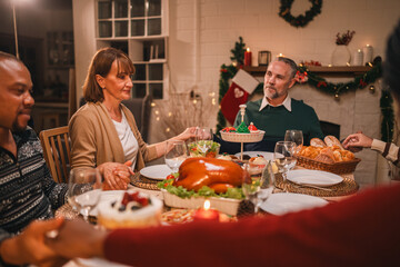 Family gathers to pray and give thanks before enjoying Christmas dinner, sharing gratitude, love,...