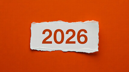 Bold “2026” printed on torn white paper over vibrant orange background, symbolizing future plans and new beginnings