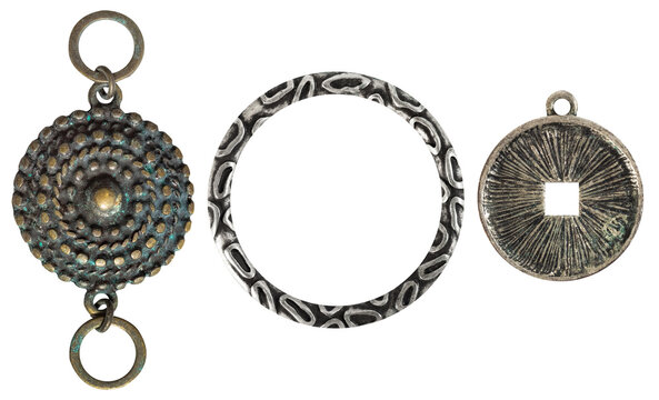Isolated photo of vintage steel and copper baroque metal decorative ethnic style pendants, brooches, earrings on white background.