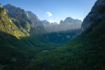 Obraz premium Prokletije (Accursed Mountains) aerial panorama at sunrise — dramatic karst peaks over a deep green valley, Montenegro