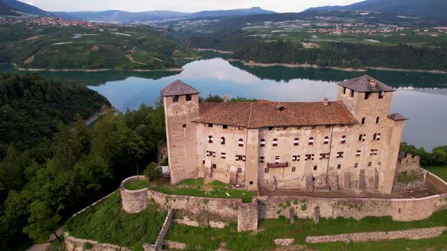 Aerial 4K Panoramic View of Castel Cles Overlooking Santa Giustina Lake &mdash; Historic Alpine Fortress Surrounded by Famous Apple Orchards in Val di Non Trentino Italy
