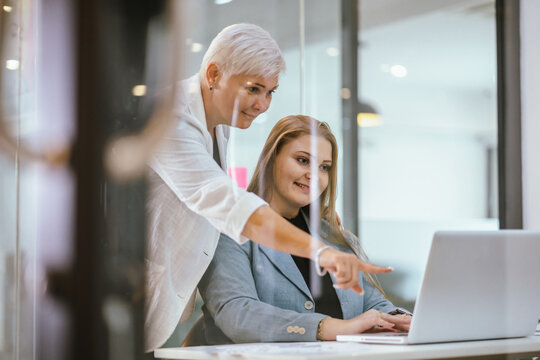 Business team analyzing data and marketing strategy in modern office, brainstorming ideas for project success using laptops and charts, teamwork collaboration for corporate growth