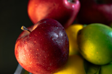 Still Life with Red Apples and Lemons in a Glass Vase on Black Background