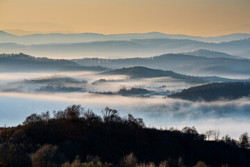 Misty Sunrise Over Layered Hills. Soft morning fog drapes across rolling hills at sunrise, creating dreamy layers of light and shadow in a tranquil. Perfect for nature and travel themes.

 

