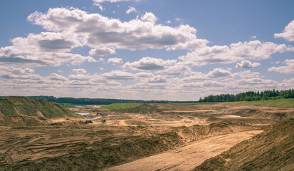 Barren, dry, and dusty landscape with a few trees scattered around