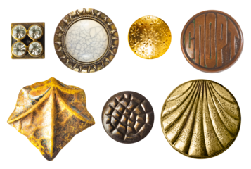 Isolated photo of various vintage bronze and gold metal decorative cloth buttons or rivets on white background.