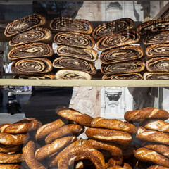  A window display showing stacks of Turkish pastries: rolled pinwheels filled with a dark paste (likely poppy seed or chocolate) on top, and bottom-half simits (sesame bread rings).