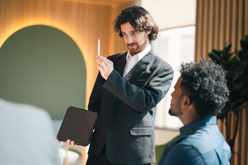 Creative business team meeting with professionals discussing project strategy, presenting ideas on board, teamwork collaboration concept in modern office environment