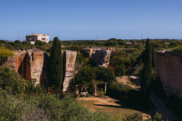 Dramatic limestone quarry labyrinth in Menorca. Abstract, textured stone walls.