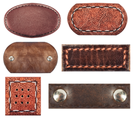 Isolated photo of various brown leather patches with stitch borders and rivets or studs on white background.