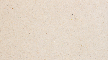 Macro of beige recycled craft paper with natural fiber and small colorful inclusions. Natural background for eco design, packaging or sustainable texture, copy space