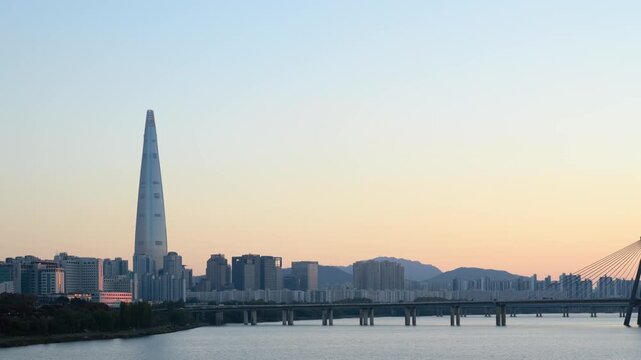 Day to night hyperlapse of Lotte World Tower and the Han River. Modern city cityscape with a parallax effect.