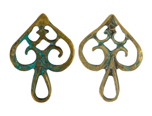 Isolated photo of rusty and worn, vintage copper metal decorative baroque style pendants or elements on white background.
