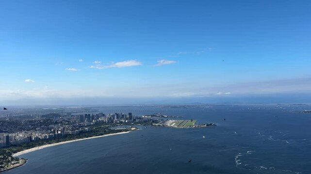 Panoramic view f in Rio de Janeiro, Brazil, overlooking Guanabara Bay, Santos Dumont Airport, the distant Rio&ndash;Niter&oacute;i Bridge, and  urban areas under partly cloudy daylight.