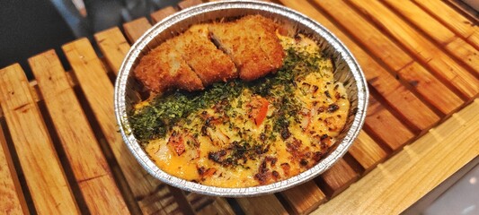 Crispy Chicken Katsu and Salmon with Japanese Mentai Rice Sauce Dish Served in a Foil Container on Wood. Food Photography Presentation