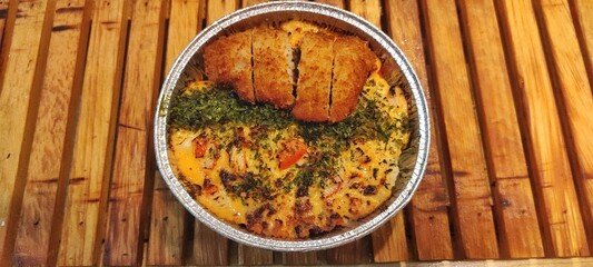 Crispy Chicken Katsu and Salmon with Japanese Mentai Rice Sauce Dish Served in a Foil Container on Wood. Food Photography Presentation