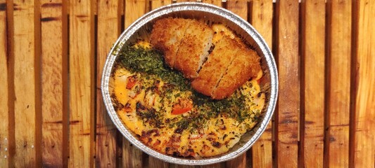 Crispy Chicken Katsu and Salmon with Japanese Mentai Rice Sauce Dish Served in a Foil Container on Wood. Food Photography Presentation