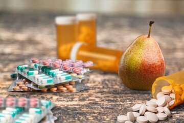 Drug prescription treatment medication in packages and fresh pear