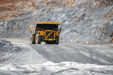 Banner industry mining. Big yellow Truck working on open pit mine of ore.