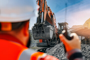 Open pit coal mine with heavy machinery and worker observing operations