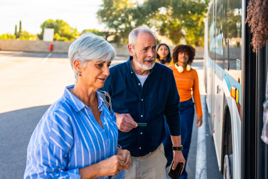 Senior couple boarding public bus for travel - Powered by Adobe