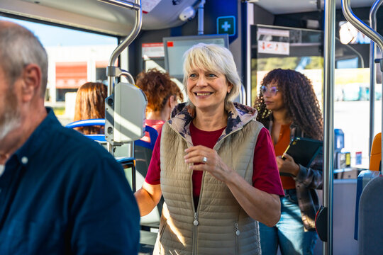 Senior woman smiling while traveling on public bus - Powered by Adobe