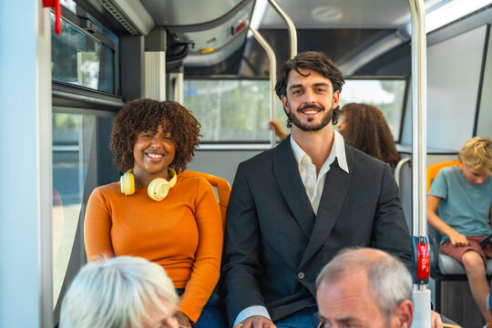 Diverse smiling people traveling together on public bus