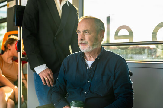 Senior man commuting on public transport bus