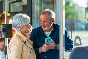 Senior couple traveling on bus using smartphone © unai