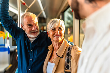 Senior couple traveling on bus talking with someone