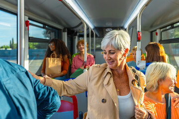 Mature women traveling by bus, enjoying public transport