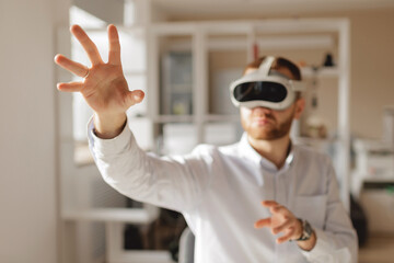 Young caucasian male engaging with virtual reality in bright indoor setting office of engineer