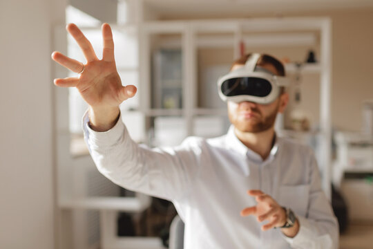 Young caucasian male engaging with virtual reality in bright indoor setting office of engineer