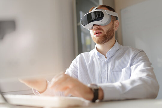 Businessman presenting virtual reality exploring VR with modern headset in office setting on video call - Powered by Adobe