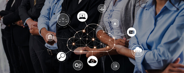 Diverse business professionals engage with cloud technology, showcasing digital icons that...