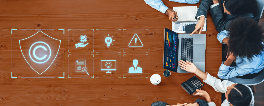 A top-down view of a business meeting focused on copyright protection, showcasing various digital icons and a laptop, highlighting strategies for safeguarding intellectual property. Trope